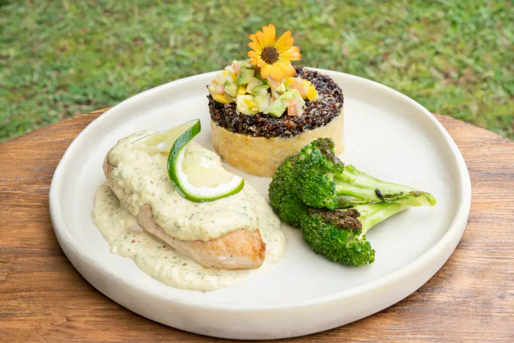 A fish fillet with broccoli and a grain timbale topped with an edible flower
