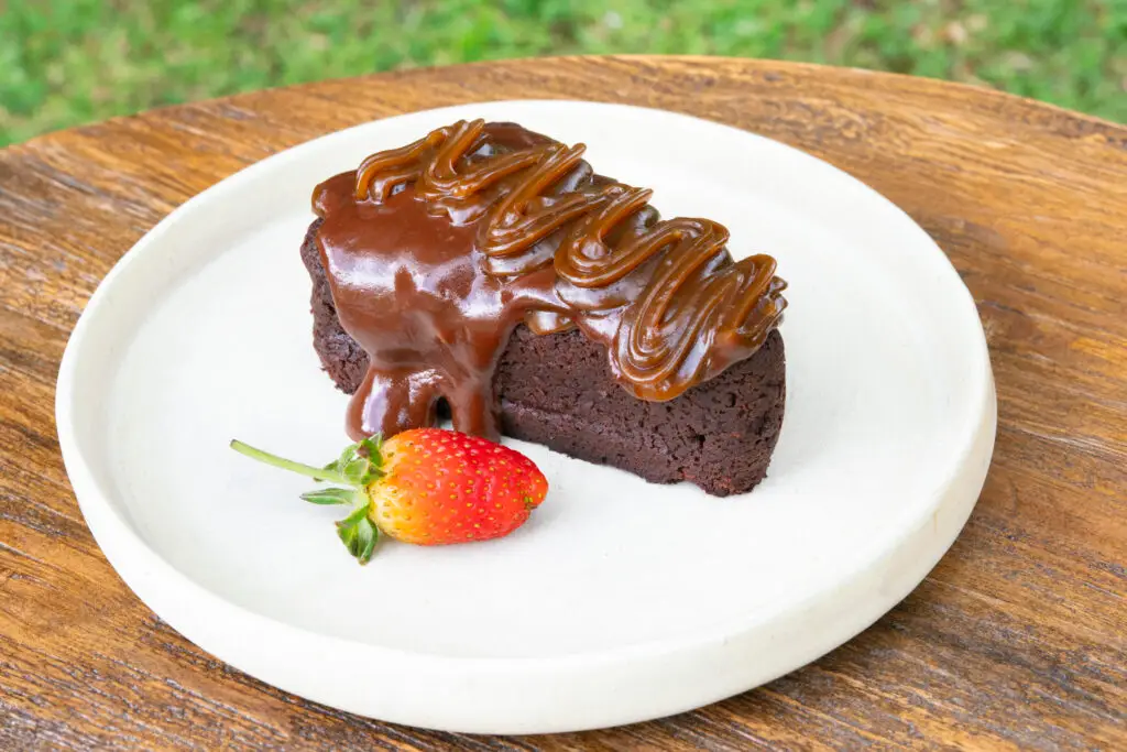 A slice of chocolate cake with a fresh strawberry