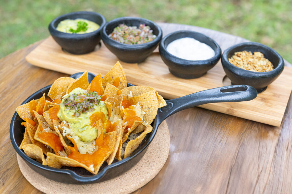 Crisp tortilla chips in a cast-iron skillet with small bowls of dips