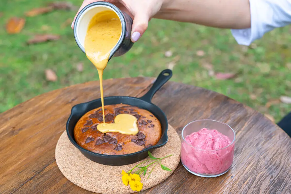 Honey being poured over a skillet pancake