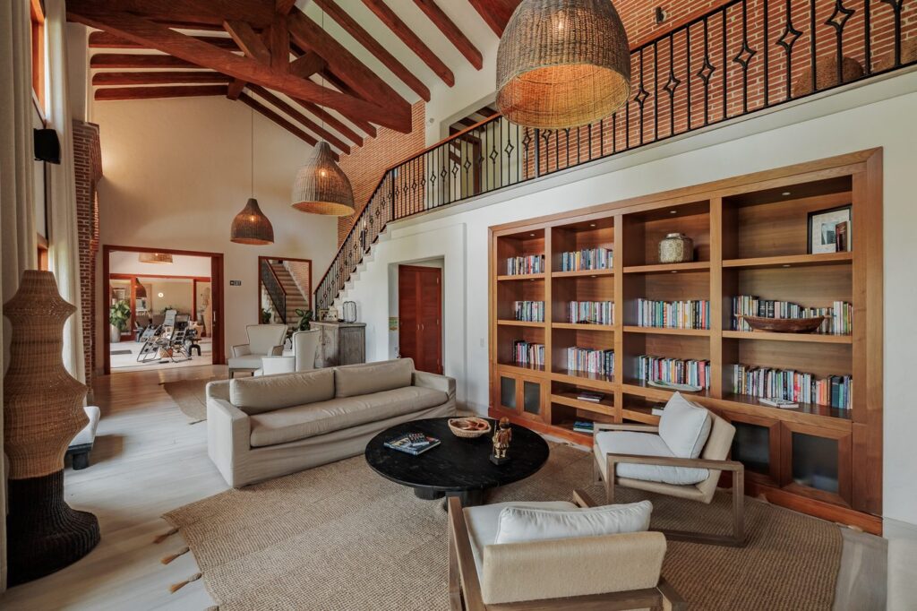 The double-height library with built-in bookshelves, armchairs and a woven pendant lamp