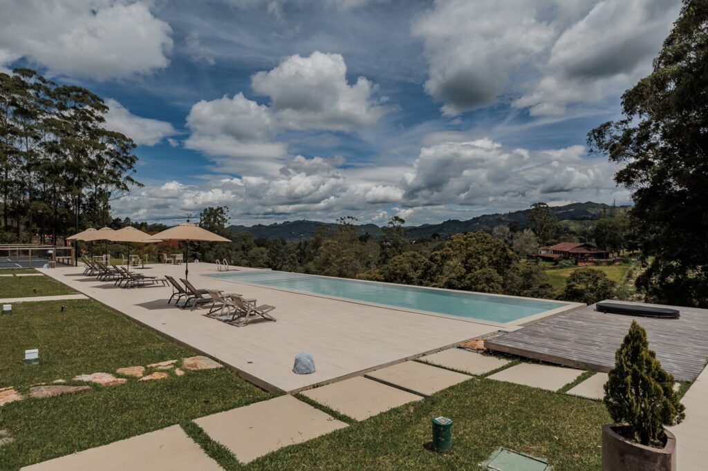 The lap pool with loungers and parasols along one side, looking out over the valley and mountains