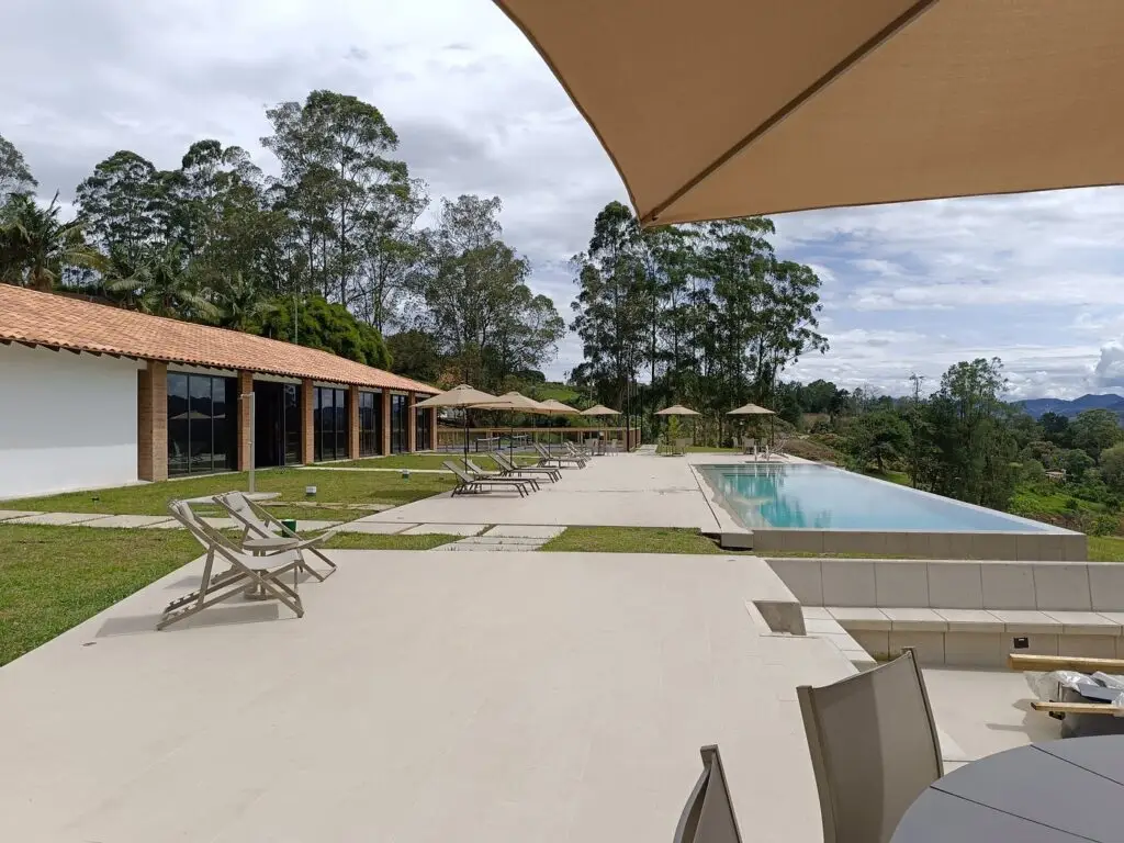 The pool deck with loungers and the long pavilion beyond