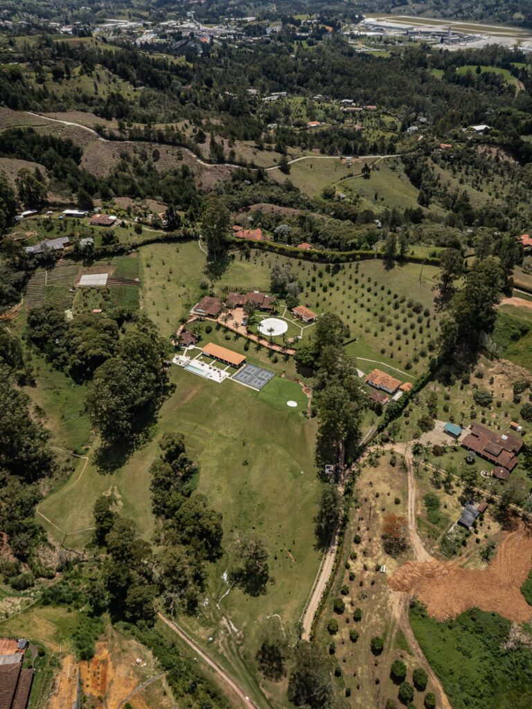 The surrounding Rionegro countryside from the air — the property small among fields, woodland and scattered farms