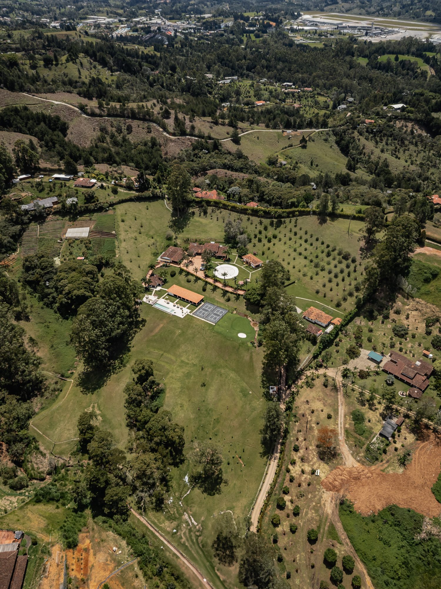 The surrounding Rionegro countryside from the air — the property small among fields, woodland and scattered farms