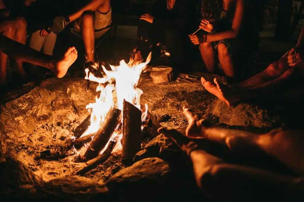 People sitting close around a fire at night