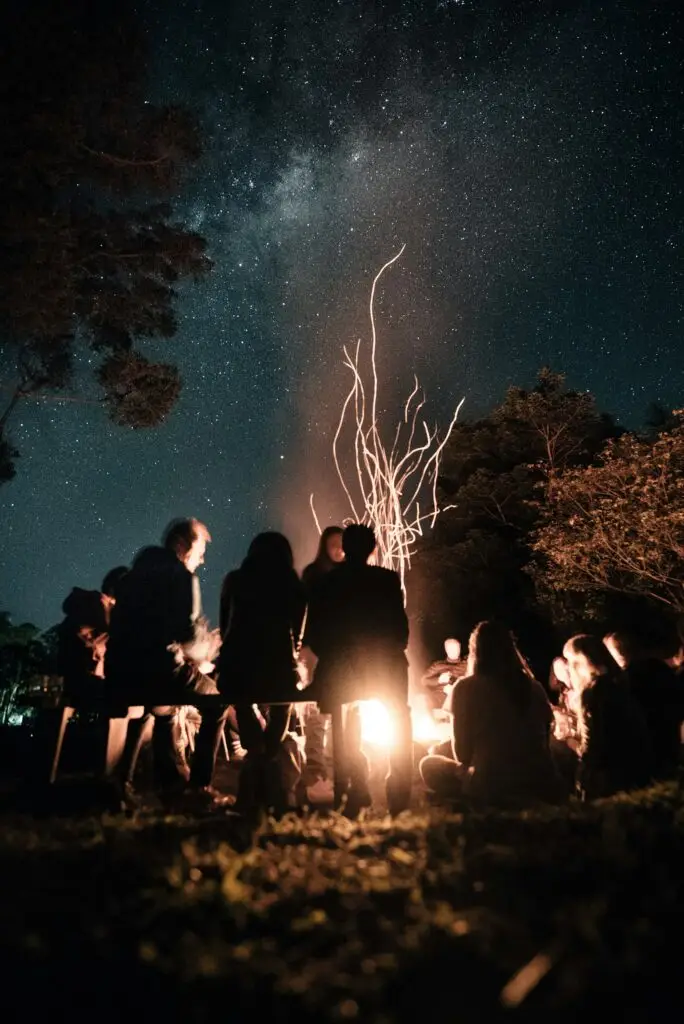 People gathered around a fire under a starry night sky